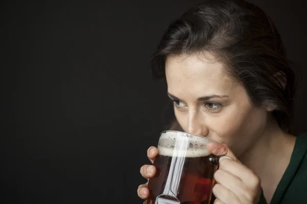 Bella giovane donna che beve una tazza di birra — Foto Stock