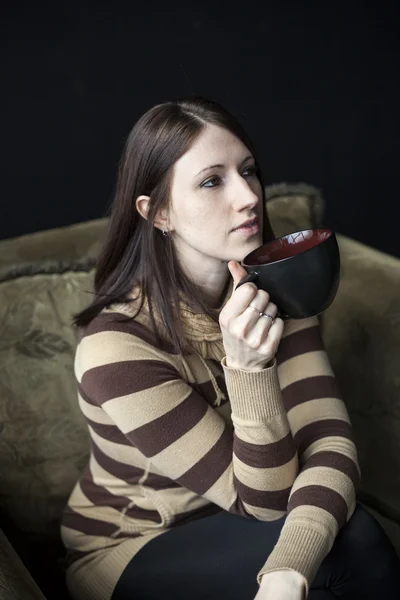 Güzel bir genç kadın kahverengi saçlı ve gözlü siyah cof holding — Stok fotoğraf