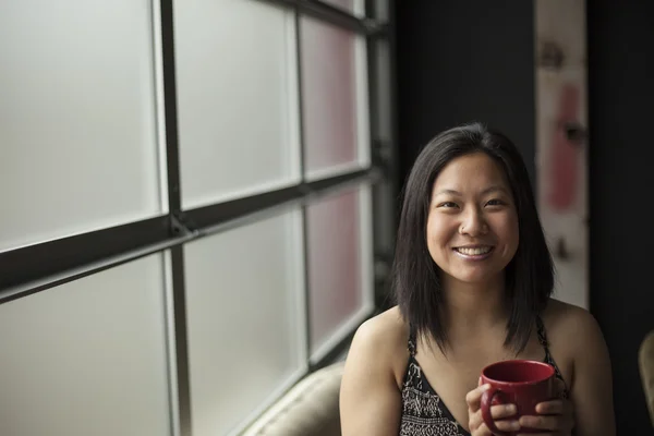 Vacker ung kvinna med brunt hår och ögon med röda kaffe c — Stockfoto