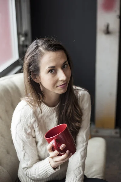 Vacker ung kvinna med brunt hår och ögon som dricker kaffe — Stockfoto