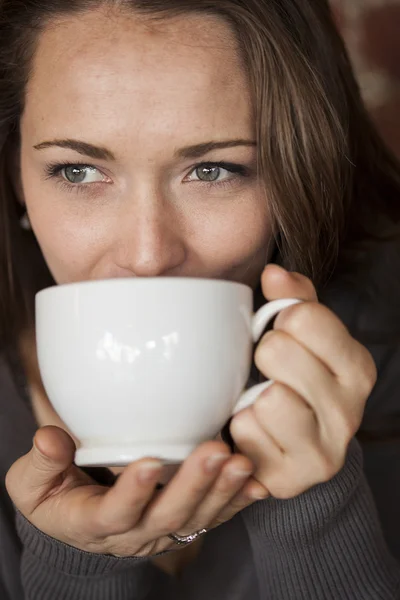 Giovane donna con bellissimi occhi verdi con tazza di caffè bianco — Foto Stock