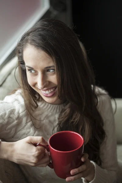 Belle jeune femme aux cheveux bruns et aux yeux buvant du café — Photo