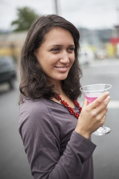 Mladá žena s krásné zelené oči pití růžové martini — Stock fotografie