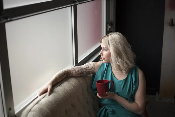 Bella giovane donna che tiene la tazza di caffè rosso — Foto Stock