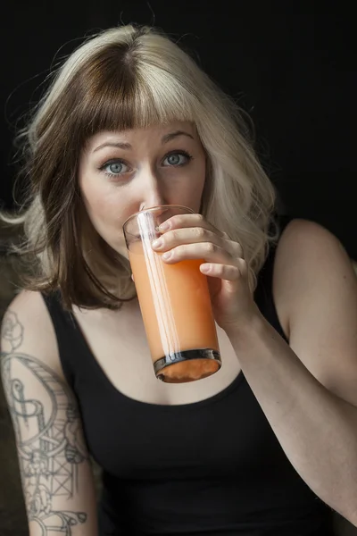 Mulher bonita bebendo suco de manga de laranja — Fotografia de Stock