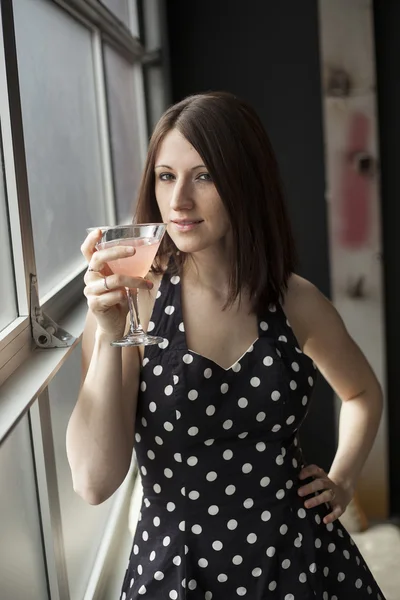 Schöne junge Frau trinkt einen rosa Martini — Stockfoto