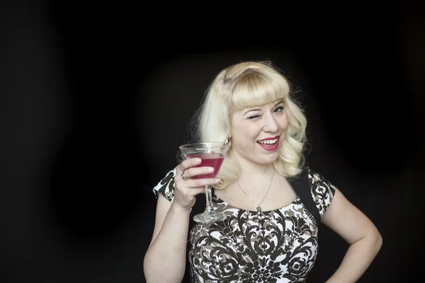 Schöne junge Frau mit blonden Haaren, die einen rosa Martini trinkt — Stockfoto