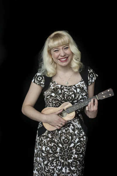 Schöne junge Frau mit blonden Haaren spielt Ukulele — Stockfoto