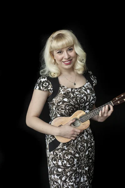 Vacker ung kvinna med blont hår spela ukulele — Stockfoto