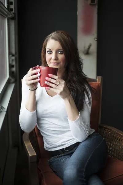 Mulher jovem com belos olhos azuis bebendo café — Fotografia de Stock