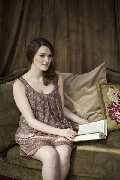 Молодая женщина с красивыми зелеными глазами читает книгу . — стоковое фото