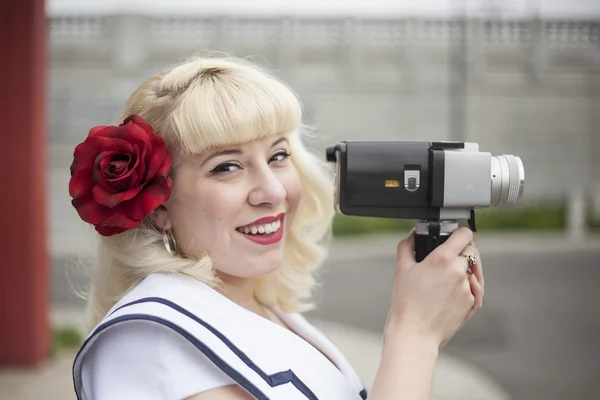 Mooie jonge vrouw met blonde haren en film camera — Stockfoto