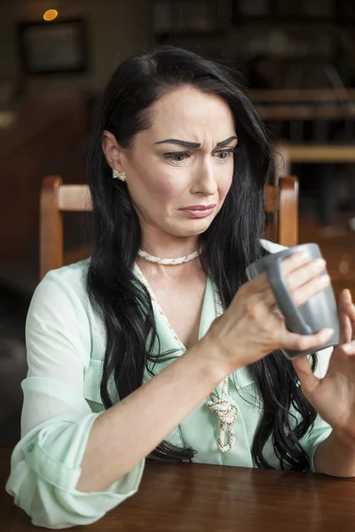 Bella giovane donna scioccata da cosa c'è nella sua tazza di caffè — Foto Stock