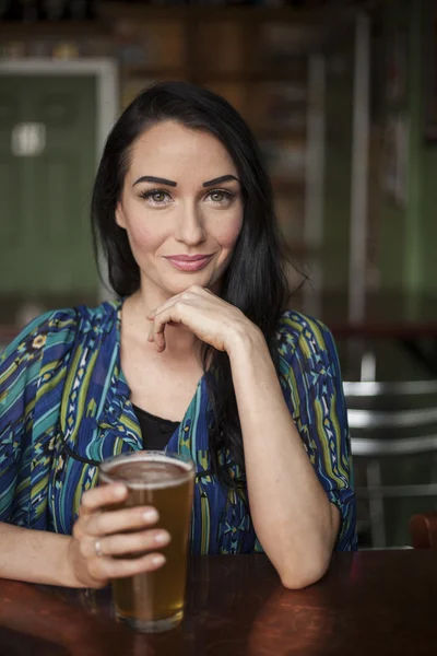Красивая молодая женщина с очень милой улыбкой и пивом — стоковое фото