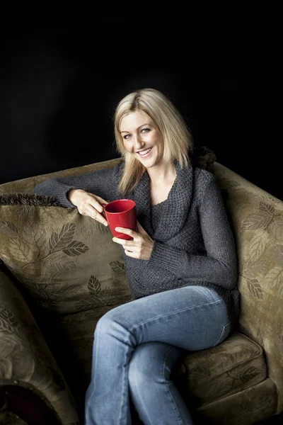 Blonde vrouw met mooie blauwe ogen en rode koffiekopje. — Stockfoto