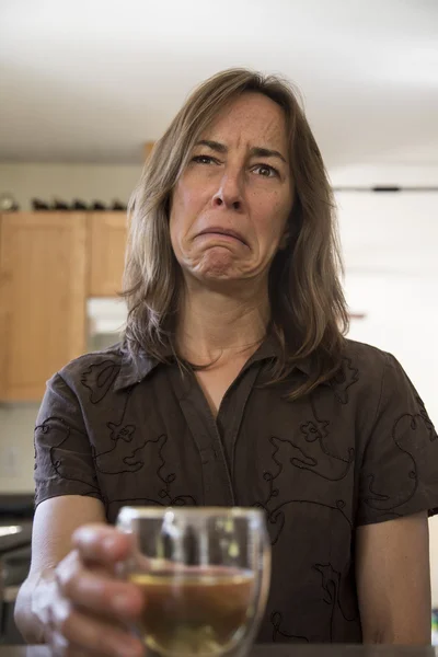 Mulher infeliz de meia-idade na cozinha bebendo vinho — Fotografia de Stock