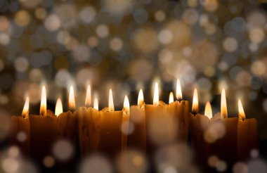 Geceleri mumlar yanıyor. Beyaz mumlar karanlıkta güzel bokeh ile yanar. kopyalama alanı.