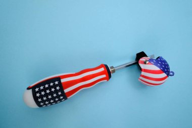 Yeni bir modern tornavida ve mavi arka planda küçük bir kask.