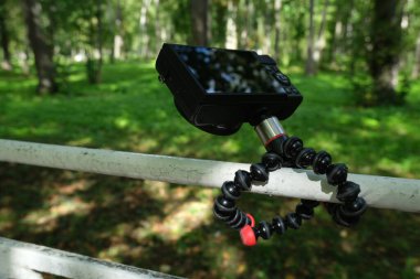 Ormanın arka planında boş bir ekran olan kamera.