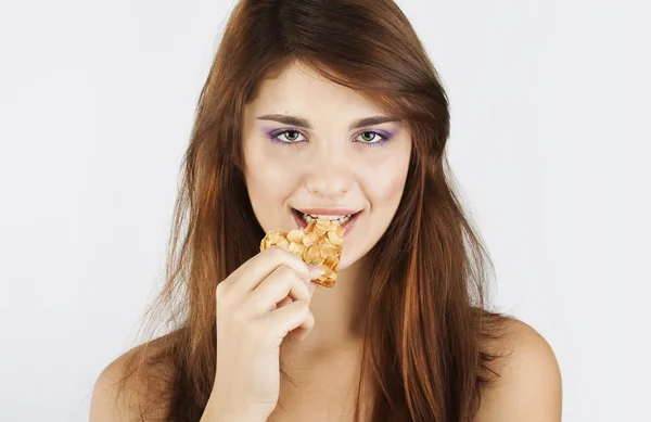 Portrait of young woman eating cookie — Stock Photo, Image