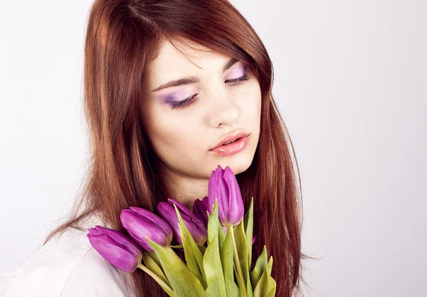 Beautiful girl with bunch of spring flowers — Stock Photo, Image