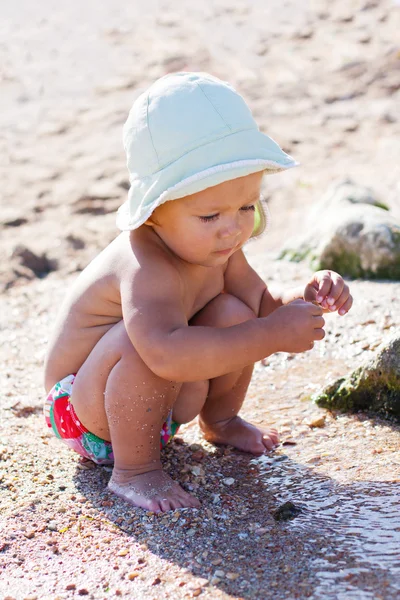 Söt baby spelar på stranden — Stockfoto