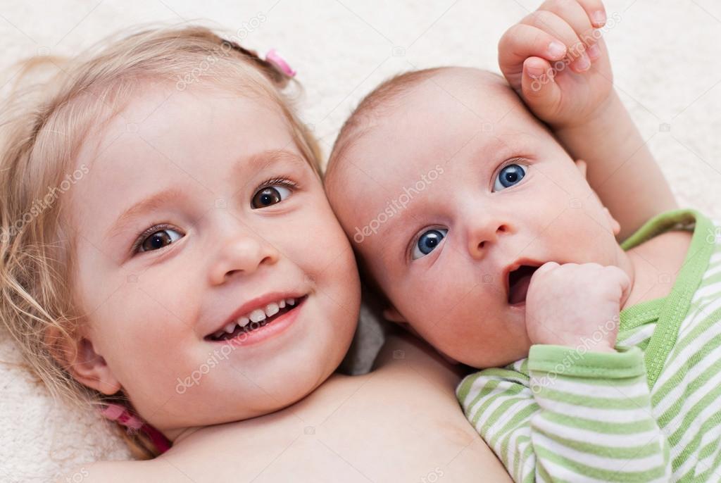 happy sister hugging baby brother