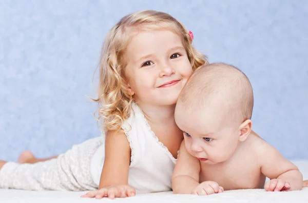 Glückliche Schwester umarmt kleinen Bruder — Stockfoto