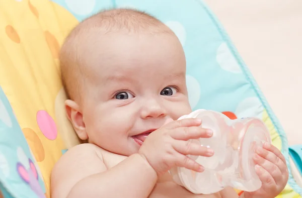 Glückliches Baby mit Flasche und Trinkwasser — Stockfoto