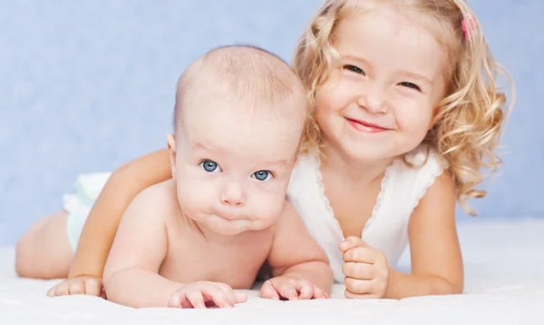 Irmã feliz abraçando irmão bebê — Fotografia de Stock