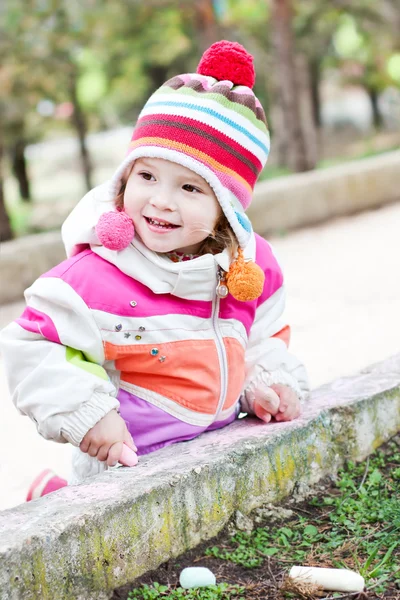 Felice bambina seduta con il gesso — Foto Stock