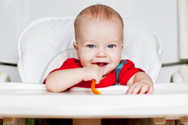 gülen bir kaşık tutan çocuk