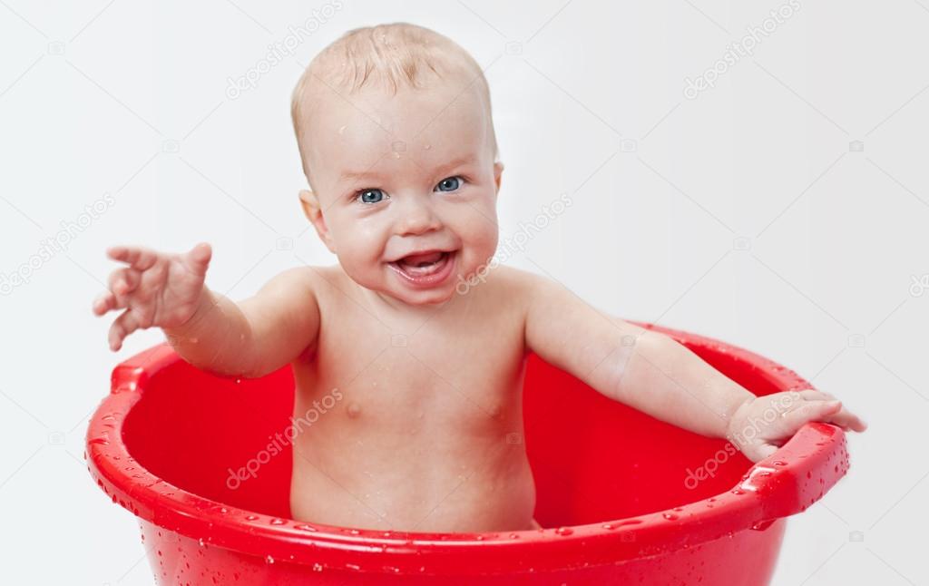 cute little babe is bathed in a basin