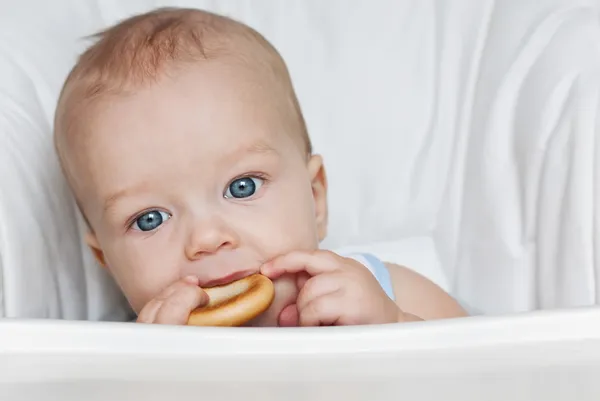 Aranyos baba fiú eszik egy bagel — Stock Fotó