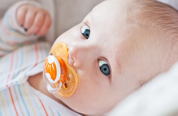 Bebê bonito com chupeta deitado em um berço — Fotografia de Stock