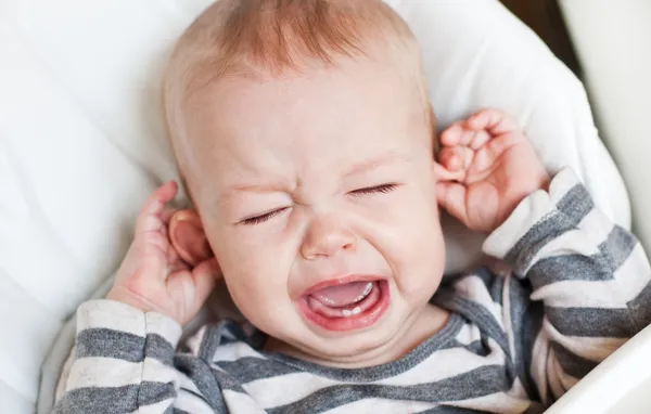 Schattige kleine jongen huilen zijn oor te houden Rechtenvrije Stockafbeeldingen