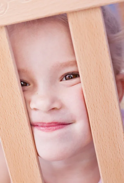 Skrattar söt liten flicka i spjälsängen — Stockfoto