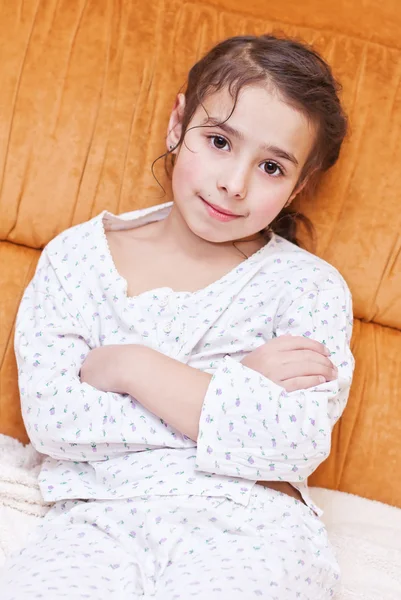 Adorable girl in pajamas sitting — Stock Photo, Image