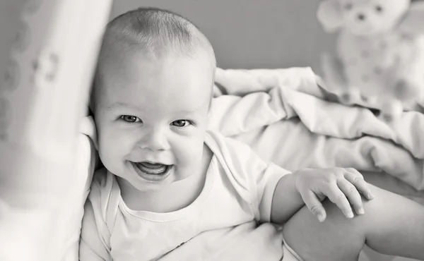 Happy baby sitting in bed — Stock Photo, Image