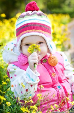 bir buket çiçek tutan mutlu küçük kız