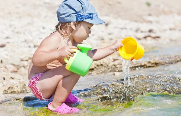 Söt baby flicka som leker på stranden — Stockfoto