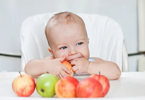 Happy baby boy eating apples — Stock Photo, Image