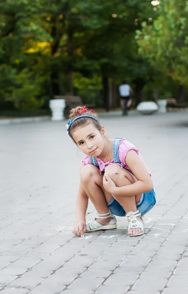 Mid felnőtt többnemzetiségű nő gyakorlása súlyzó és mosolyogva néz a néző描画チョークでかわいい女の子 — ストック写真