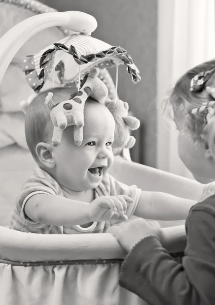 Glad baby dreng leger med sin søster - Stock-foto