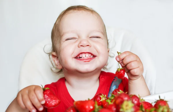 Happy toddler boy eating strawberries — Stock Photo, Image
