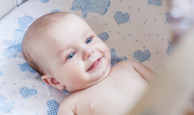 Happy baby lying in the cradle clipart