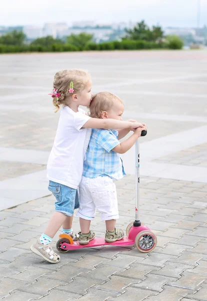 Brother and sister ride scooters — Stock Photo, Image
