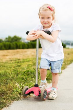 scooter üzerinde sevimli küçük kız