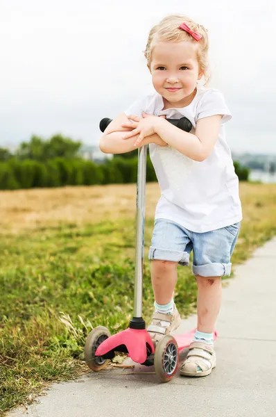 Милая маленькая девочка на скутере — стоковое фото