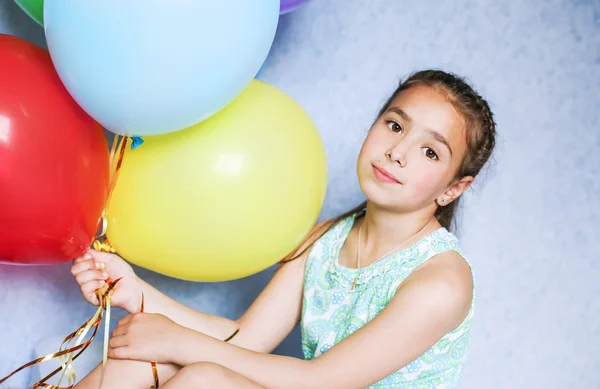 Niedliches Mädchen mit bunten Luftballons — Stockfoto